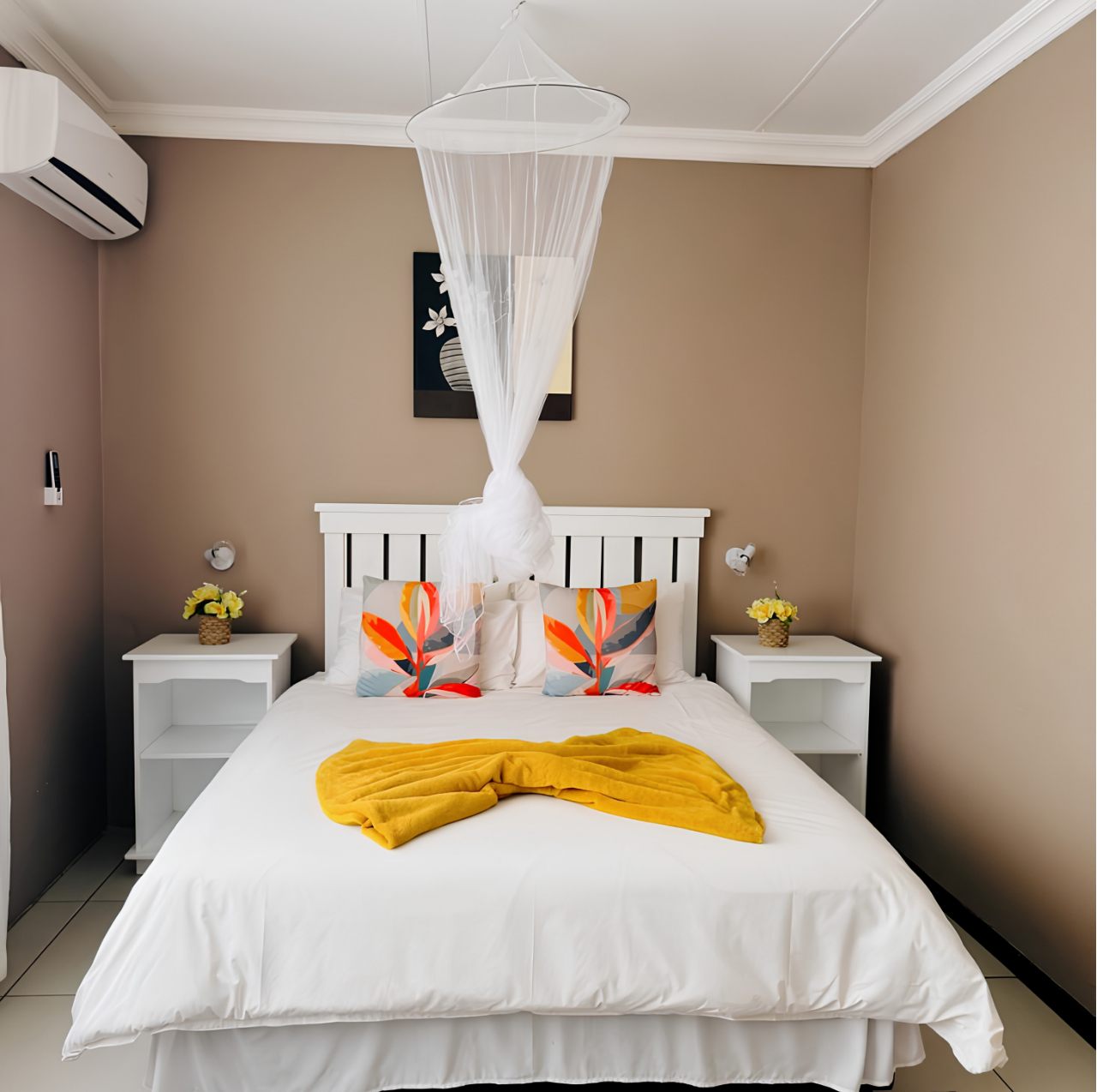 Double Room at Omateko Lodge, front view with double bed, colourful pillows and yellow throw